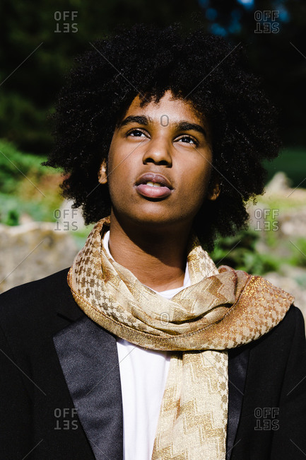 A close up shot of a young african american man posing in a brown scarf