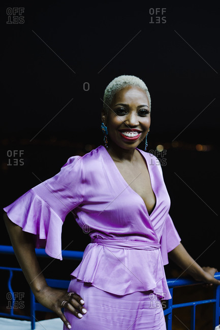 Vertical portrait of a woman in a purple dress smiling at the camera
