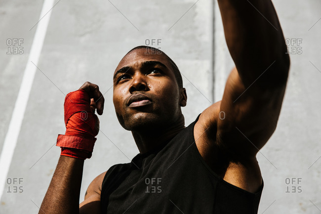 Close up shot of a male boxer performing a left jab with his hands covered in boxing wraps
