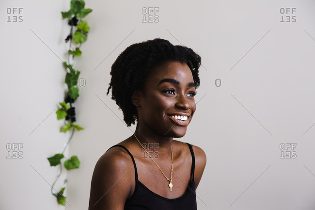 Portrait of a black model smiling in front of a white wall