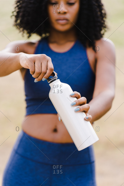 Portrait of a woman opening water bottle