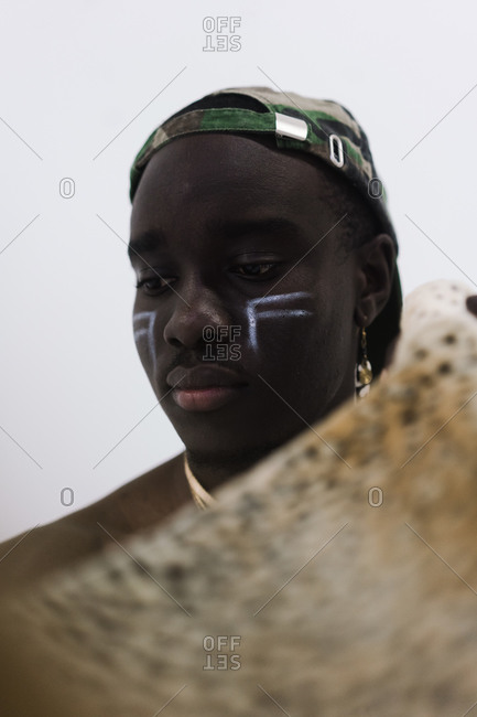Close up vertical portrait of a young man with lowered eyes in African attire