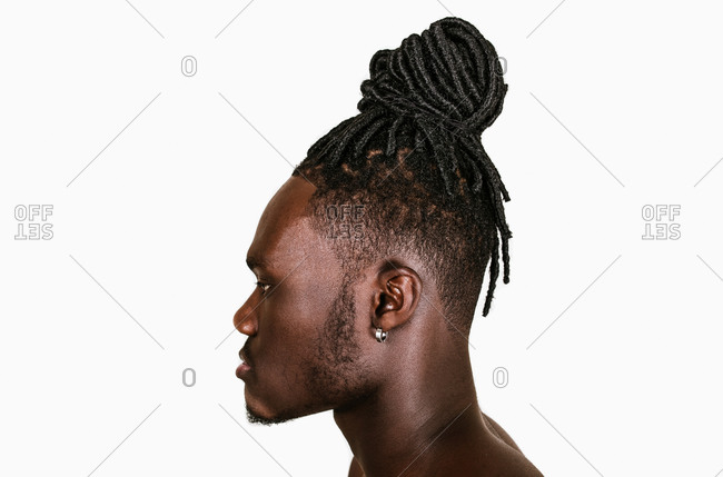 A side profile close up shot of a black man with dreadlocks hairstyle on a white background