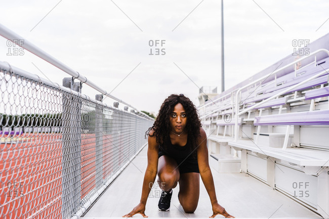 Black female athlete prepares to run on track