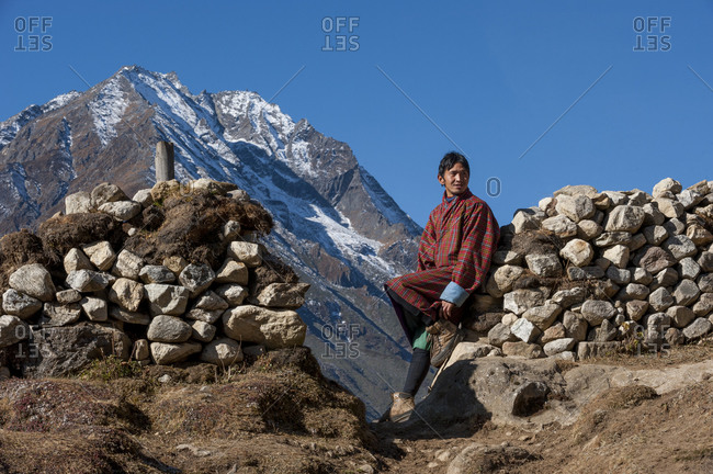 Laya, Gasa District, Bhutan - November 18, 2009: A Layap man leans against a dry stone wall in the remote village Laya