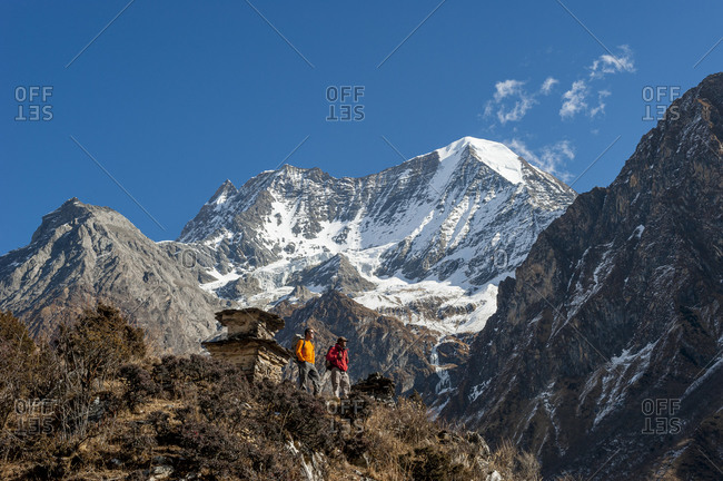 Trekkers stand and admire the view by a chorten near Samogaon