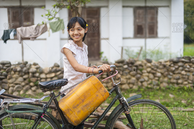 A girl uses a bicycle to get water