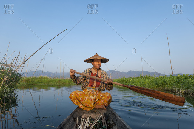 A woman paddles home through the floating gardens on Inle lake
