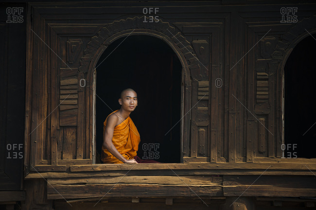 A monk looks out from the window of Nat Taung Kyaung  monastery