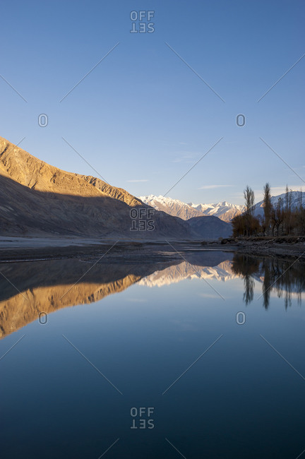 Karakoram range mountains reflected in the Shyok river