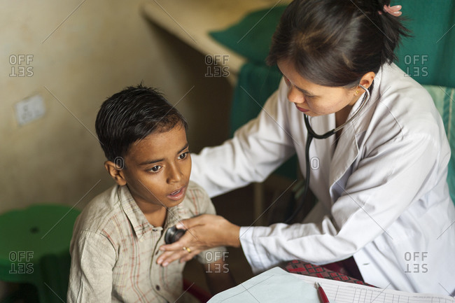 A doctor checks a boys chest with a stethoscope in a rural hospital in Nepal