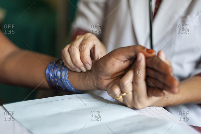 A doctor checks a patients pulse in a rural hospital in Nepal