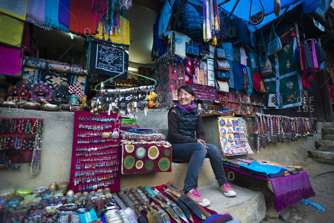 Central region, Nepal - November 13, 2012: A Tibetan woman sitting outside her shop in Namche Bazaar