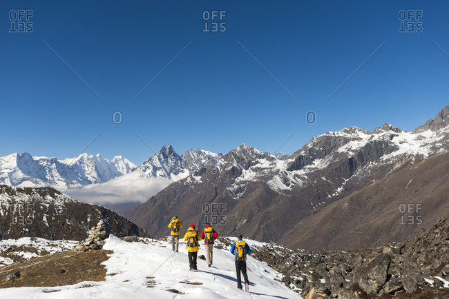 A climbing team make their way to Ama Dablam base camp in the Everest region of Nepal with views of Kantega and Thermserku in the distance