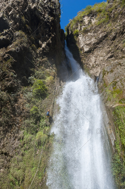 A man abseils down a 100m waterfall in Nepal near the Tibetan border