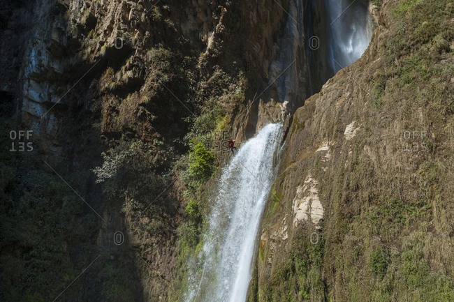 A man abseils down a 100m waterfall in Nepal near the Tibetan border