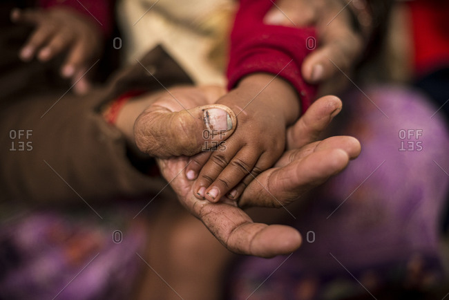A mother holds her baby’s hand in a rural hospital