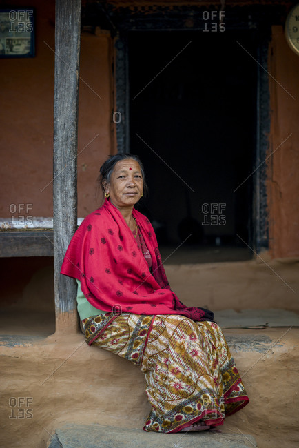 Myagdi, Beni district, Nepal - November 27, 2013: Elderly woman sitting outside her house