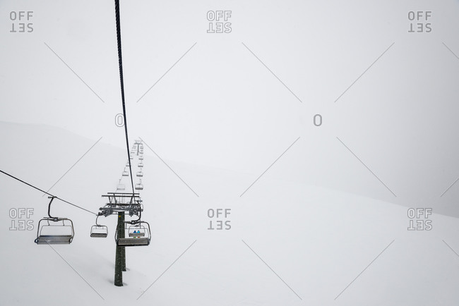 A chairlift in the Italian Dolomites disappears into the mist during a whiteout