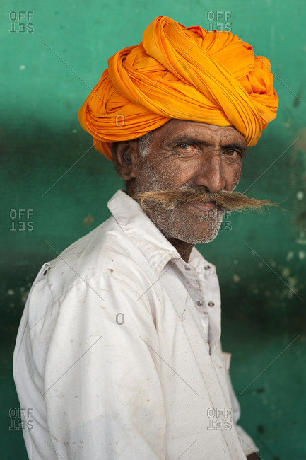A Rajasthani man with a typically large moustache and bright turban sits in a Chai shop near Jodhpur