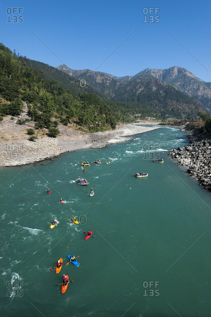 Rafts and kayaks drift down the Karnali river in west Nepal