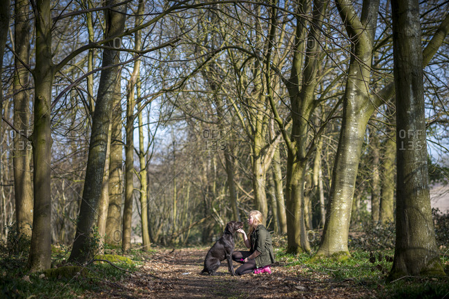 A young girl with her German Shorthaired Pointer in the woods