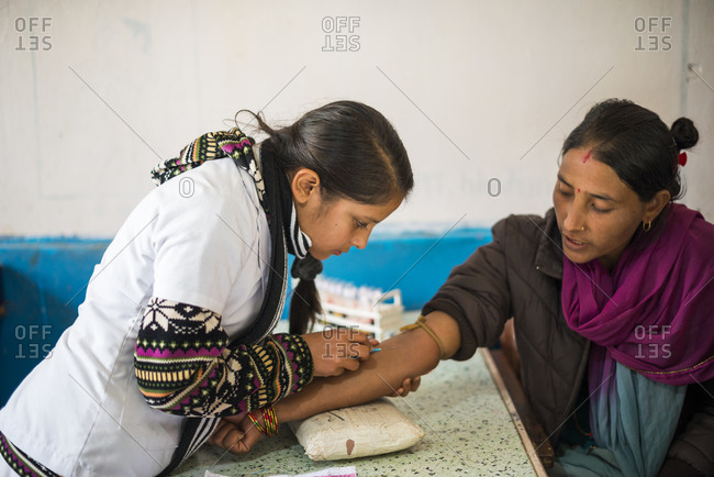 A woman gives a sample of blood at a hospital in Nepal