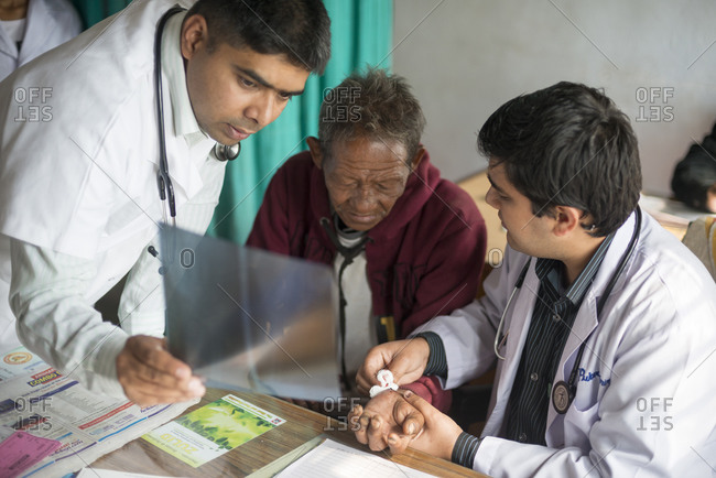 Myagdi, Beni district, Nepal - November 27, 2013: Doctors discuss an x-ray with a patient at Myagdi hospital