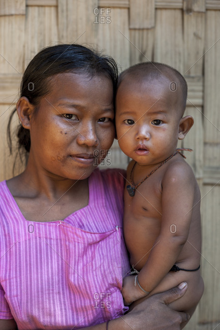 A mother holds her baby, the little necklace is to keep away evil spirits and sickness