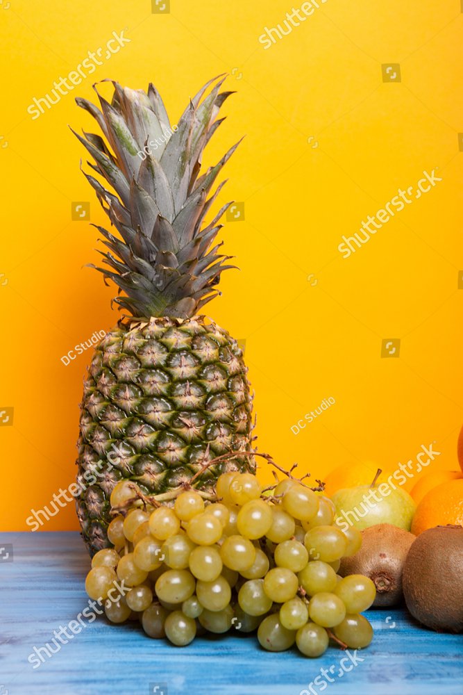 Pineapple, grapes and other fruits on yellow background. Various fruits
