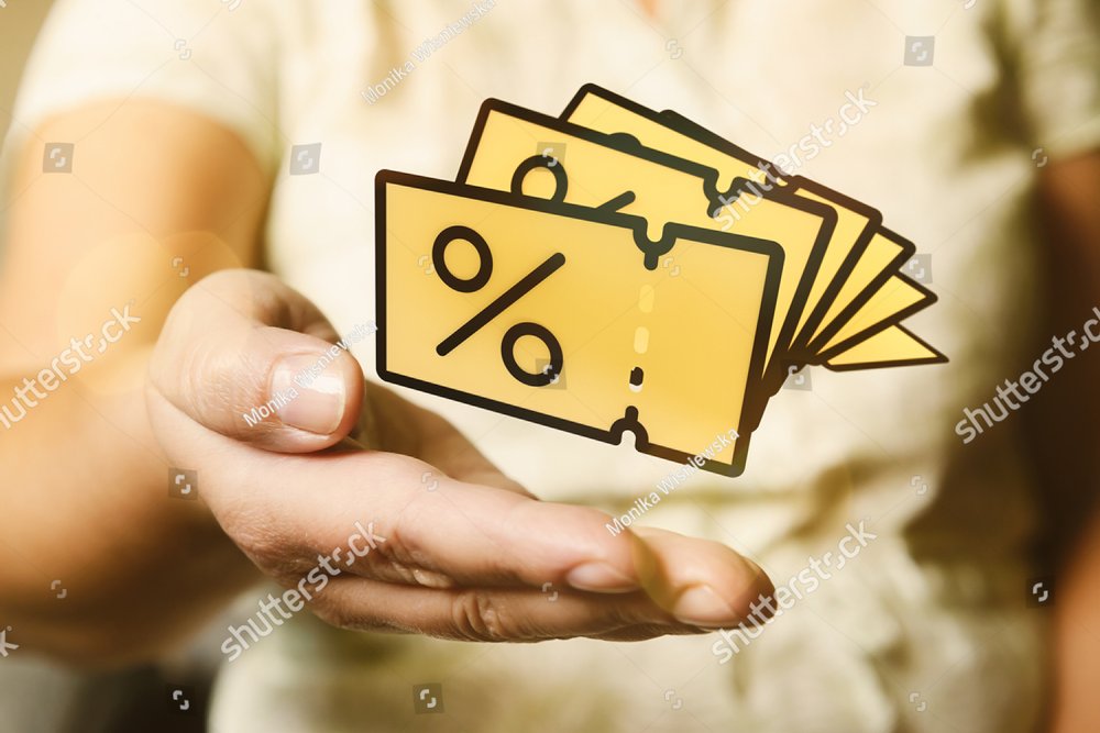 Hand with yellow promo code coupons. Sale or discount conceptual photo.