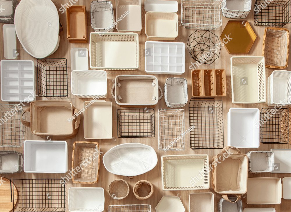 Top view of empty closet organization boxes and steel wire baskets in  different shape placed on white marble table with copy space. Marie Kondo's  hikidashi boxes for tidying clothes and drawer storage