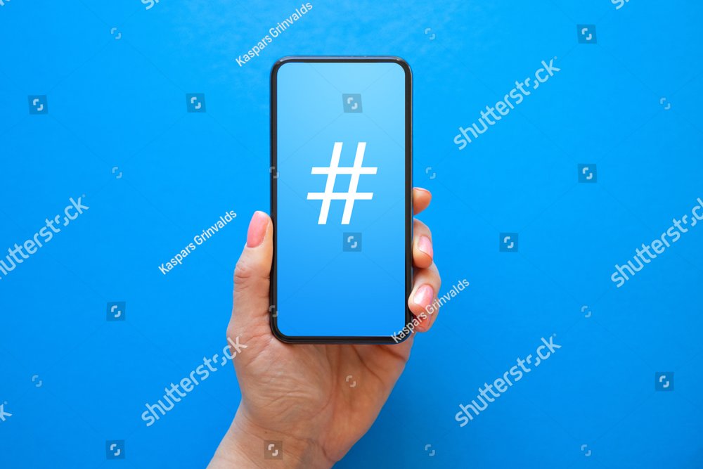 Person holding mobile phone with hashtag symbol on the screen