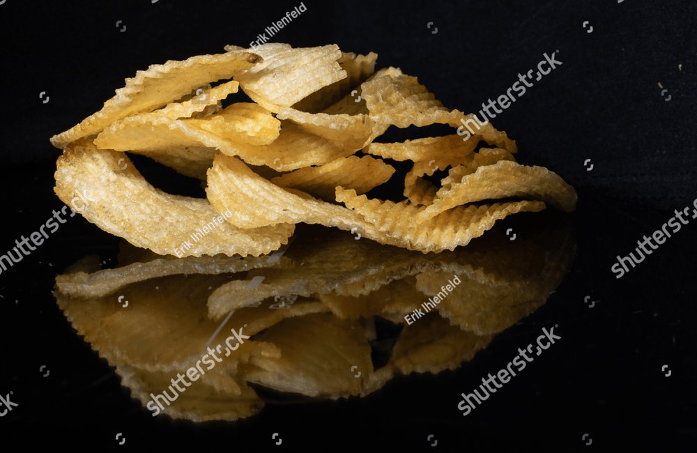 Premium Photo  Potatoe chips with raw potatoes on black background. copy  space