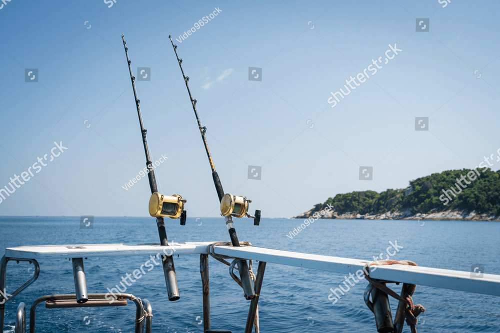 The best Fishing reels and rods reels for big game fishing trolling tuna.blue  sky and blue water.Andaman sea fishing, Phuket, Thailand.Copy space and  text Space. Background Stock Photos