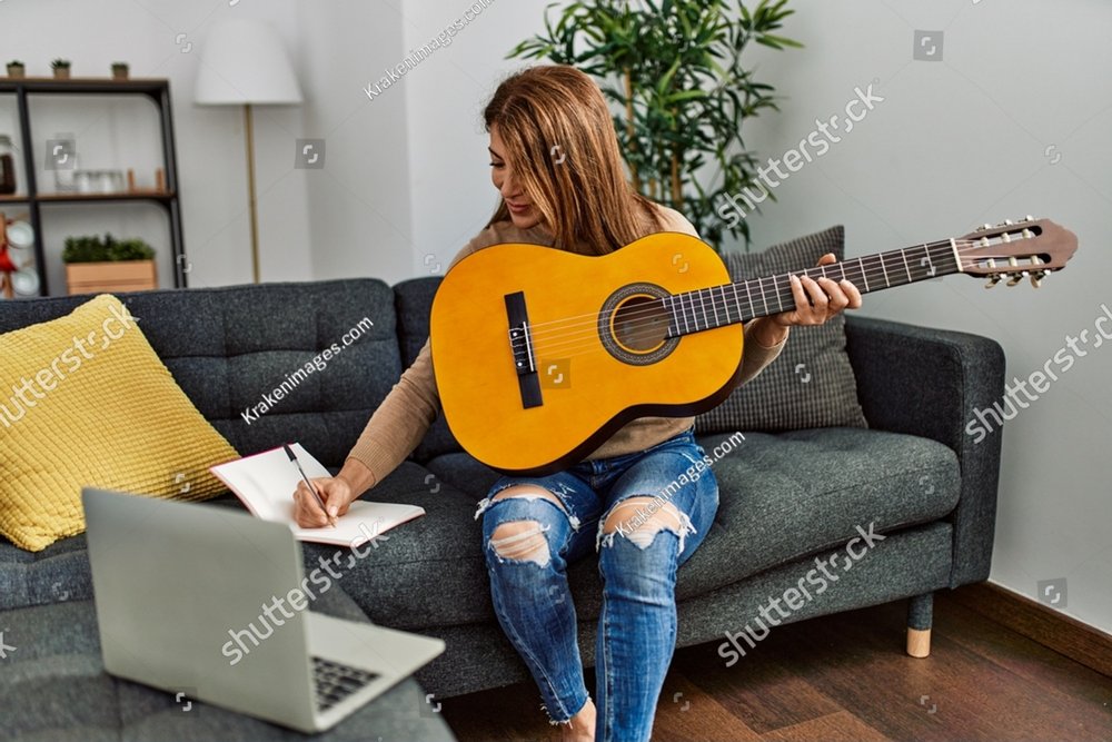 Middle age caucasian woman writing lyrics song sitting on the sofa at home.