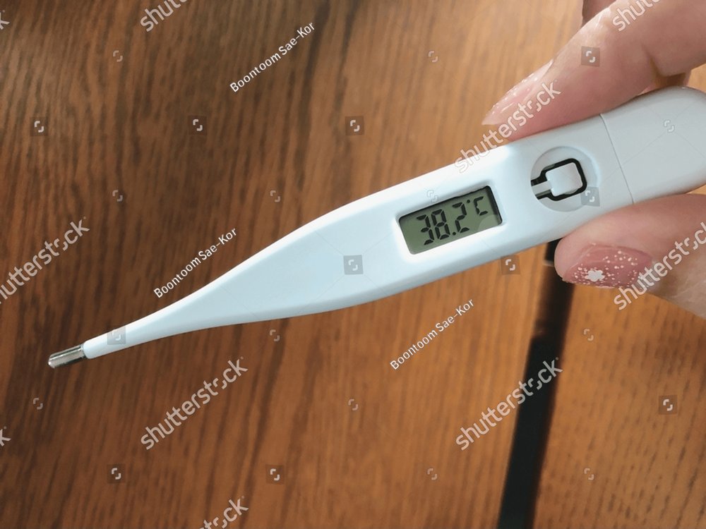 Clinical digital oral thermometer showing temperature 38.2 degrees Celsius.  Asian adult who have a fever using axillary thermometer. Health care  content, Coronavirus disease or COVID-19 theme. Health & Medical Stock  Photos