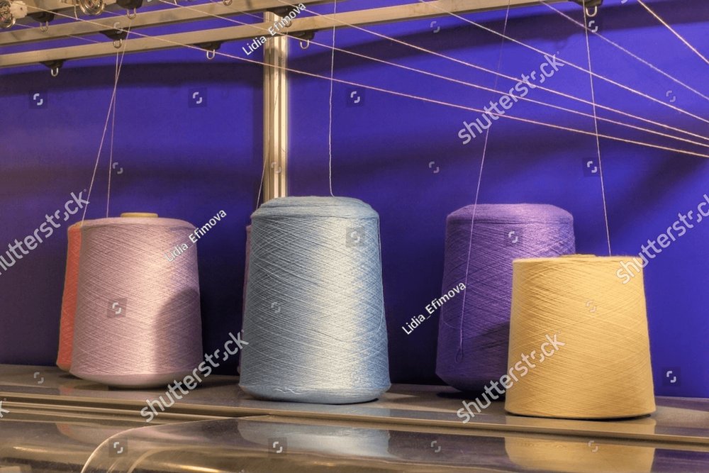 Close-up of spools of color threads, spinning machine. Yarn bobbins making  in a textile factory. Embroidery machine in garment industry. Dyeing  fabrics yarn. Sewing material tool Business Images