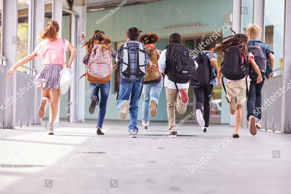 Group of elementary school kids running at school, back view