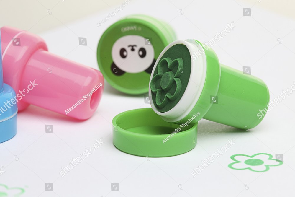 Kids stamps, a couple of green and blue ear plugs sitting on top of a white  table School & Education Stock Photos