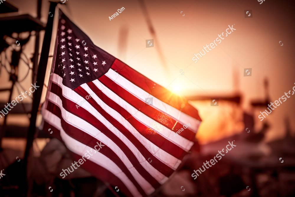 Flag of United States of America flutters in the winds in mild sunset light, independence day of America