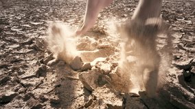 Close up crazy jumps of barefoot man on dry cracked earth slow motion video