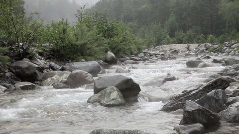 HD. fast and rocky mountain river in the summer in the rain