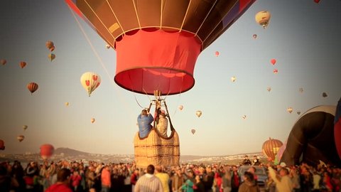 Spectators watching a hot air ballon departing with family in an annual festival