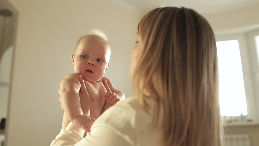 Mother kissing her child,sun lens flare,dolly shot