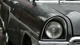 Old-fashioned cars in the rain. Close-up of headlight and front side of old cars in the rain. 4K UHD video.