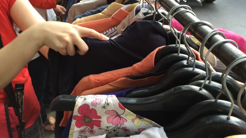 Female hands look through womens clothes in a second hand shop. Royalty-Free Stock Footage #10033454
