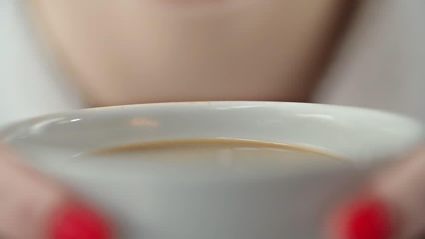Extreme close up of female mouth sipping from the cup of coffee | Shutterstock HD Video #10037408