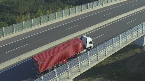 AERIAL: Container truck driving over the highway viaduct