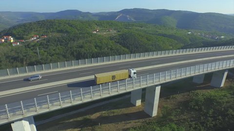 AERIAL: Container truck transporting cargo on a viaduct freeway